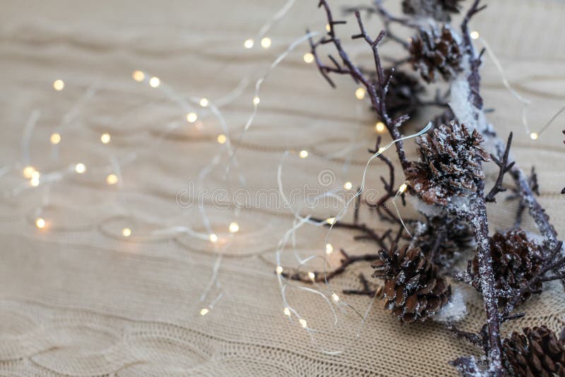 Composizione nel nuovo anno ed in Natale Chiuda sui rami della neve con i coni e sulla ghirlanda su fondo bianco tricottato fotografie stock Composizione nel nuovo anno ed in Natale Chiuda sui rami della neve con i coni e sulla ghirlanda su fondo bianco tricottato fotografie stock
