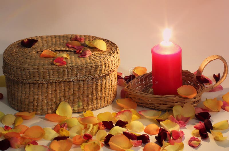 Composizione romantica Amore Canestro di vimini e candela e petali di rosa intrecciati intorno immagine stock libera da diritti Composizione romantica Amore Canestro di vimini e candela e petali di rosa intrecciati intorno immagine stock libera da diritti