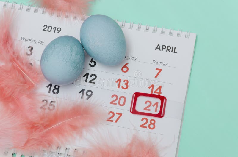Composição bonito das penas, ovos pintados, calendário com marca vermelha o 21 de abril na superfície brilhante imagem de stock royalty free Composição bonito das penas, ovos pintados, calendário com marca vermelha o 21 de abril na superfície brilhante imagem de stock royalty free