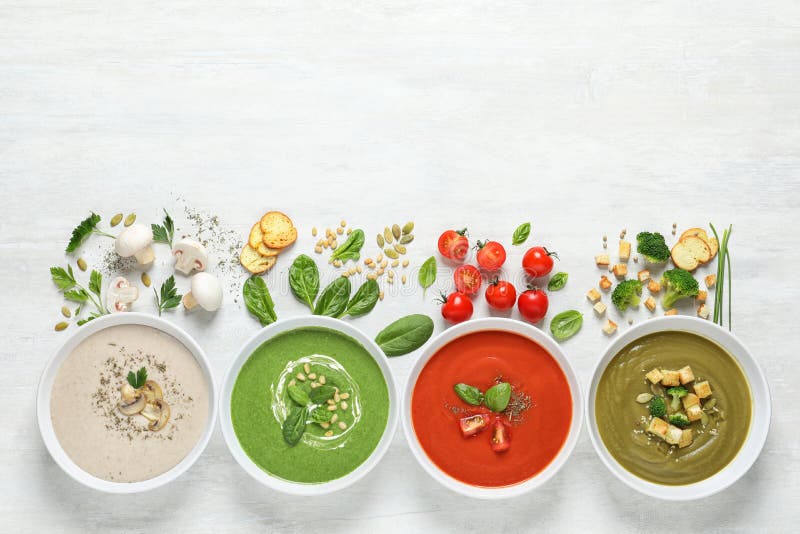 Composição colocada lisa com os vários sopas, ingredientes e espaço para o texto no fundo branco imagem de stock royalty free Composição colocada lisa com os vários sopas, ingredientes e espaço para o texto no fundo branco imagem de stock royalty free