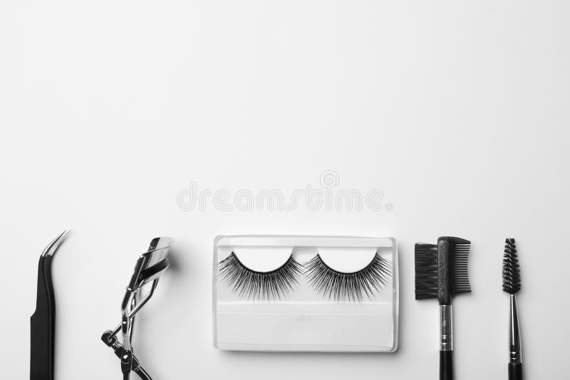 Flat lay composition of professional makeup tools and false eyelashes on white background. Flat lay composition of professional makeup tools and false eyelashes on white background