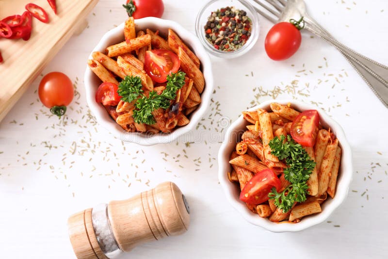 Composição com massa saboroso do penne na tabela branca imagem de stock Composição com massa saboroso do penne na tabela branca imagem de stock