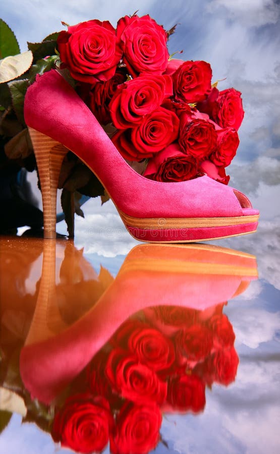 Composition with red roses and pink female shoe on sky background. Composition with red roses and pink female shoe on sky background