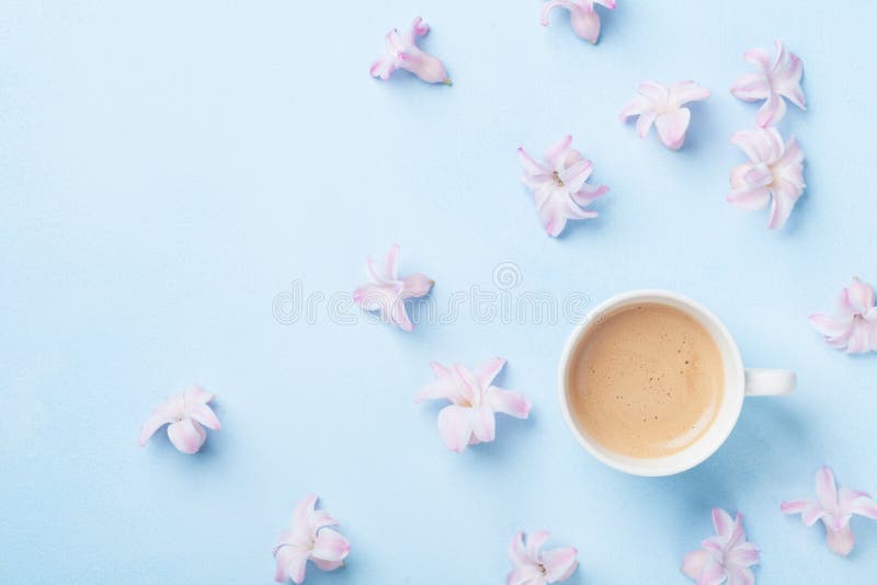 Creative composition with morning coffee and pink flowers on blue pastel background top view. Flat lay. Creative composition with morning coffee and pink flowers on blue pastel background top view. Flat lay.