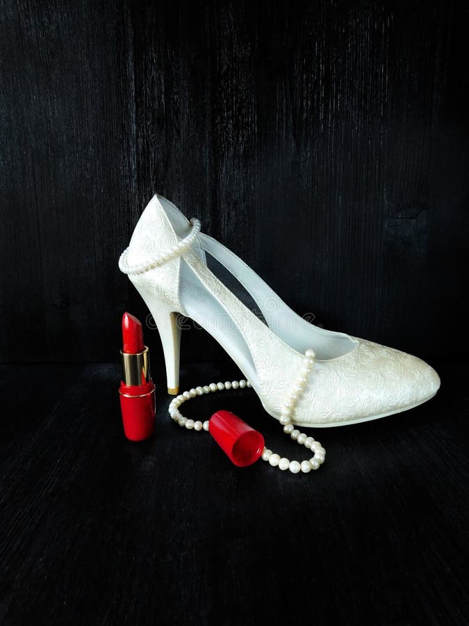Composição glamoroso feita dos saltos brancos, do batom vermelho e da colar da pérola foto de stock royalty free Composição glamoroso feita dos saltos brancos, do batom vermelho e da colar da pérola foto de stock royalty free