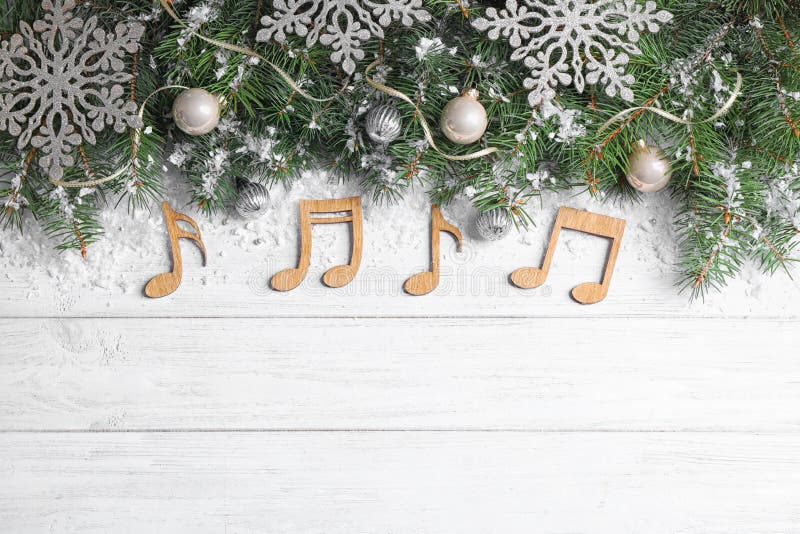 Flat lay composition with Christmas decor and music notes on white wooden table, space for text. Flat lay composition with Christmas decor and music notes on white wooden table, space for text