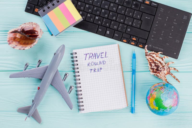 Composição plana com planícies do avião, conchas e bloco de notas em mesa azul. fotos de stock royalty free