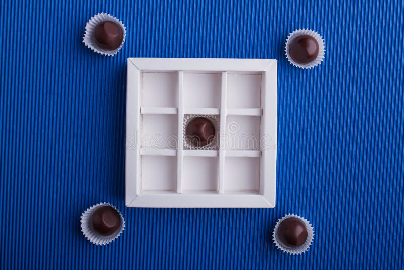Composição plana de chocolates escuros com caixa. fotografia de stock royalty free