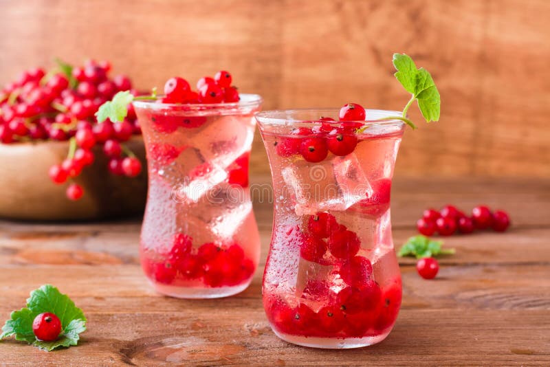 Compota fría con los cubos de hielo de bayas frescas de la pasa roja fotos de archivo libres de regalías Compota fría con los cubos de hielo de bayas frescas de la pasa roja fotos de archivo libres de regalías