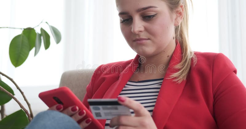 Compra da mulher em linha com telefone celular e cartão de crédito