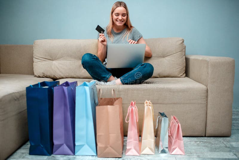Compra em linha em casa A mulher feliz nova com cartão de crédito está pronta às grandes vendas na loja em linha ao sentar-se no imagem de stock Compra em linha em casa A mulher feliz nova com cartão de crédito está pronta às grandes vendas na loja em linha ao sentar-se no imagem de stock