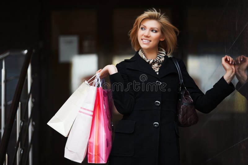 Jovem e feliz mulher da moda com sacos de compras fotografia de stock royalty free