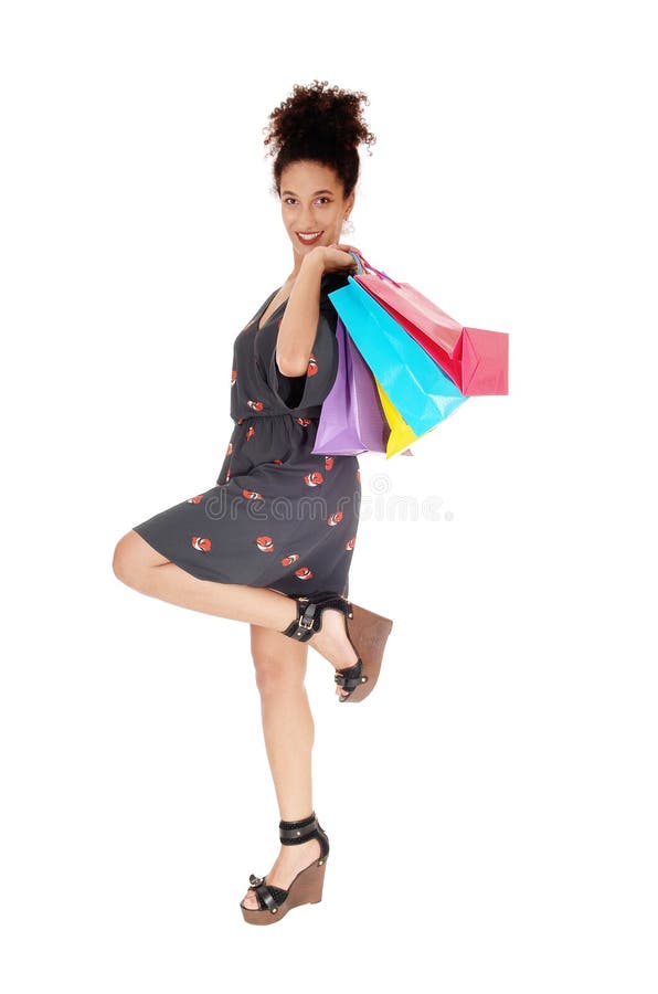 Compra feliz da jovem mulher com os sacos sobre seu ombro fotografia de stock Compra feliz da jovem mulher com os sacos sobre seu ombro fotografia de stock