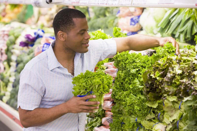Compras del hombre en la sección del producto imágenes de archivo libres de regalías Compras del hombre en la sección del producto imágenes de archivo libres de regalías