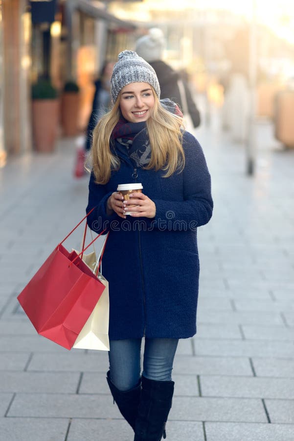Compras magníficas de la Navidad de la mujer joven hacia fuera foto de archivo libre de regalías Compras magníficas de la Navidad de la mujer joven hacia fuera foto de archivo libre de regalías