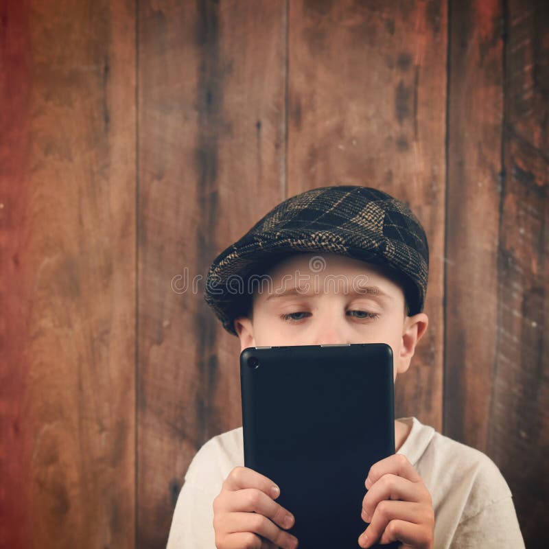Compressa di tecnologia della lettura del bambino su legno immagini stock libere da diritti Compressa di tecnologia della lettura del bambino su legno immagini stock libere da diritti