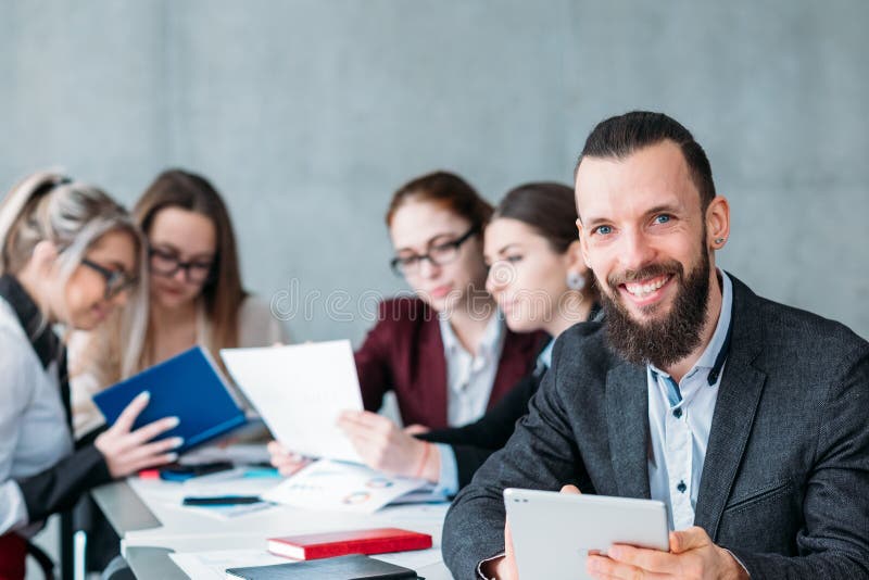 Idle employee. Team member slacking off during business meeting. Smiling carefree men with tablet at workplace. Idle employee. Team member slacking off during business meeting. Smiling carefree men with tablet at workplace.