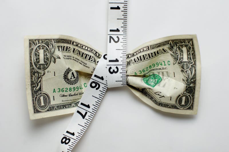 Dollar bill being squeezed by tape measure on white background. Dollar bill being squeezed by tape measure on white background.