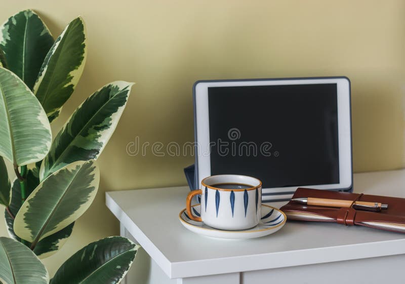 Comprimido de café no interior e uma xícara de café sobre a mesa na sala de estar imagens de stock royalty free