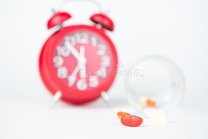 Comprimé de médecine, distribuant l'horloge en verre et rouge photo libre de droits Comprimé de médecine, distribuant l'horloge en verre et rouge photo libre de droits