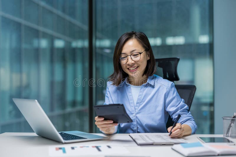 Comptable de financier féminine qui a réussi à travailler avec des papiers et des documents à l'intérieur du bureau. Une femme asi photo libre de droits