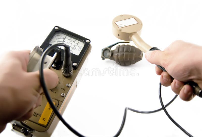 Geiger counter/surveyor with probe measuring radiation of vintage grenade. Geiger counter/surveyor with probe measuring radiation of vintage grenade