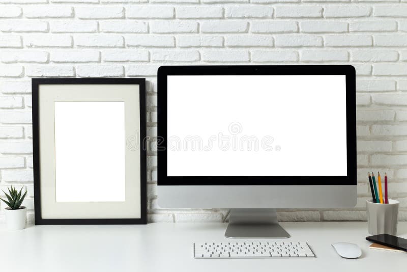 Computer de tip „mockup” cu ecran alb gol și cadru pentru afișaj gol cu spațiu de lucru și materiale de birou pe birou royalty free stock image