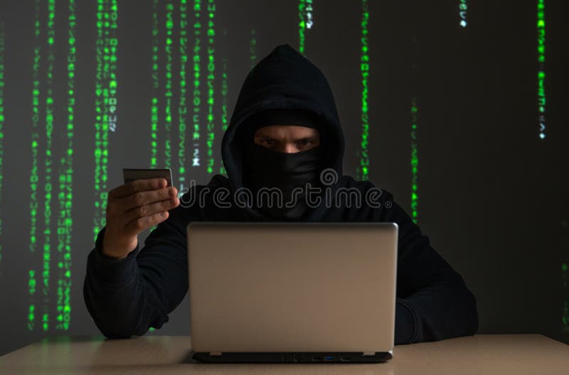 Computer Hacker with Credit Card Stealing Data from a Laptop Concept