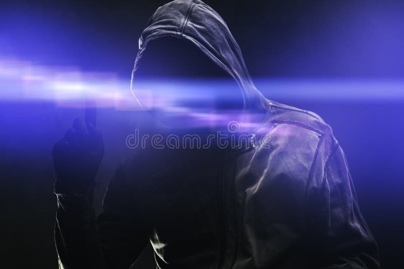Computer hacker in hoodie using virtual screen. Database hacking, computer virus malware and cybersecurity concept stock photography