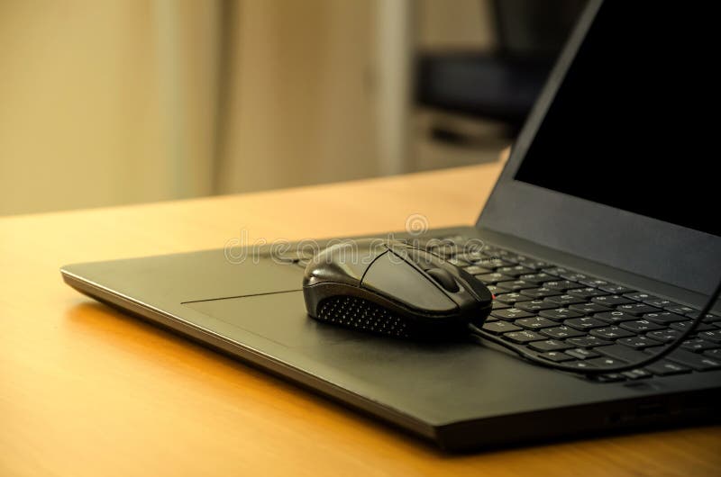 Computer Mouse On Laptop Keyboard On The Background Of The Office Desk