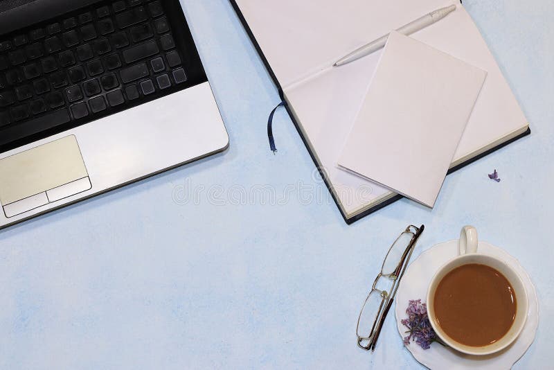 Computer, notebook and cup of coffee on a light table., Top view