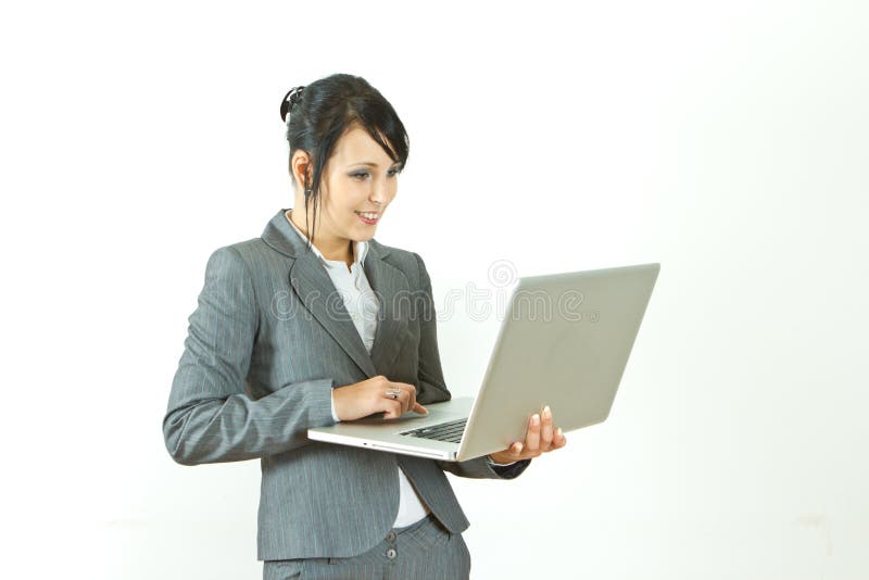 Computer portatile diritto sorridente della holding della donna di affari fotografia stock Computer portatile diritto sorridente della holding della donna di affari fotografia stock