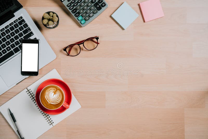 Computer portatile, occhiali, calcolatore, blocco note, taccuino, smartphone e tazza di caffè sulla scrivania con lo spazio della immagine stock Computer portatile, occhiali, calcolatore, blocco note, taccuino, smartphone e tazza di caffè sulla scrivania con lo spazio della immagine stock