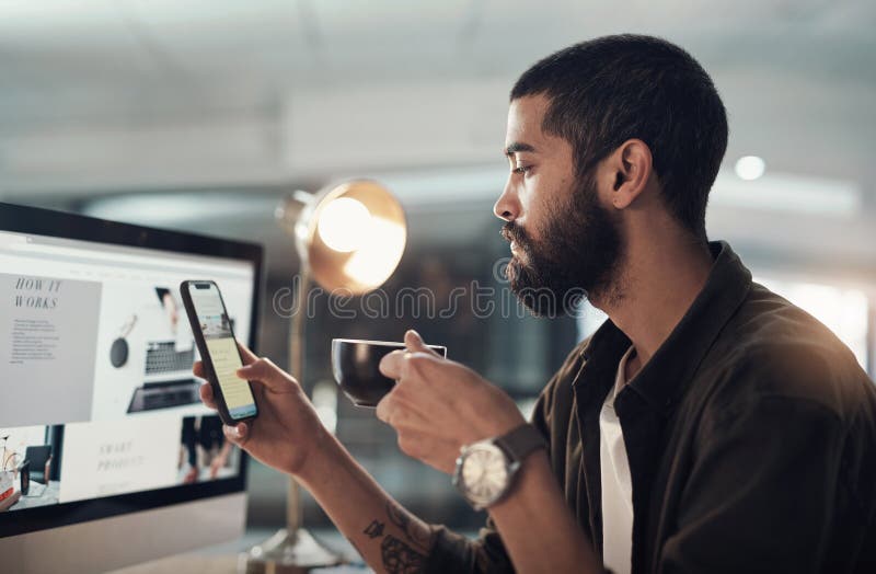 Computer screen, coffee and man on mobile in office on overtime at night in creative startup. Phone, drink beverage and stock image