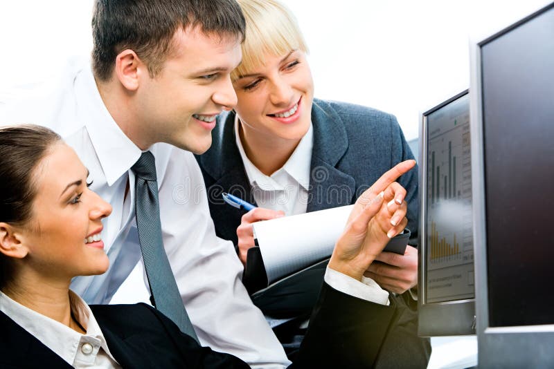 Computer work. Portrait of three business people sitting near computer and looking at its screen with smiles Computer work. Portrait of three business people sitting near computer and looking at its screen with smiles