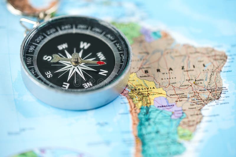 Compás con el fondo del mapa del mundo del Brasil foto de archivo libre de regalías Compás con el fondo del mapa del mundo del Brasil foto de archivo libre de regalías