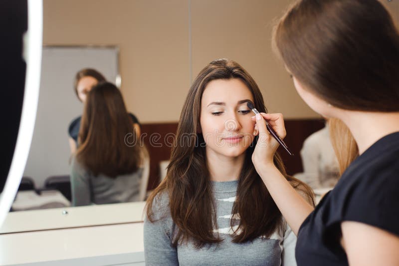 Compõe o artista que faz o profissional para compor da jovem mulher Escola da beleza foto de stock royalty free Compõe o artista que faz o profissional para compor da jovem mulher Escola da beleza foto de stock royalty free