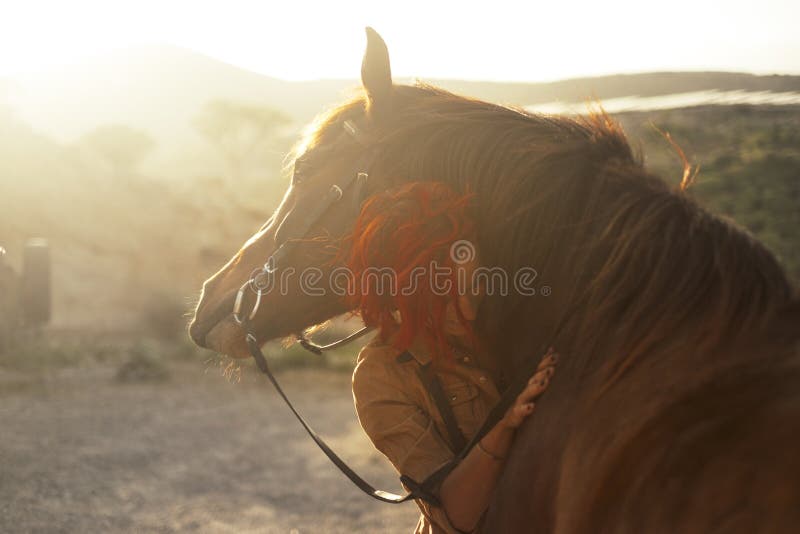 Love horse animal pet therapy red hair young pretty woman hug with affection her best friend - sunset sunlight in backlight - outdoor leisure activity and friendship concept. Love horse animal pet therapy red hair young pretty woman hug with affection her best friend - sunset sunlight in backlight - outdoor leisure activity and friendship concept