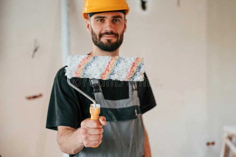 Con rotolo. l'uomo sta riparando nell'appartamento immagini stock