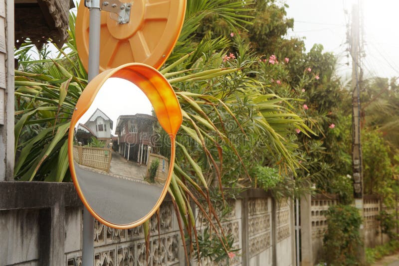 The concave mirror is attached to the corner of the street or opposite the house entrance.