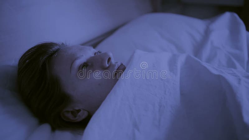Conceito da insônia A mulher na cama na noite não pode dormir
