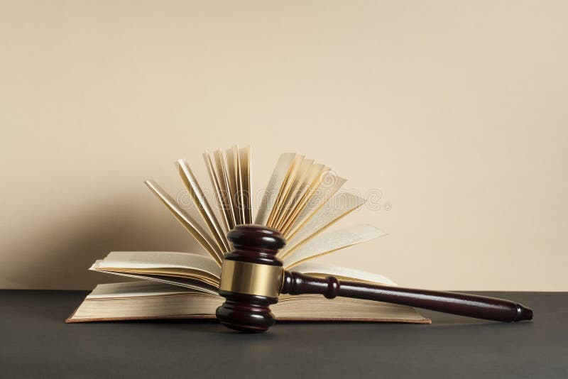 Conceito da LEI Livro aberto com o martelo de madeira do juiz na tabela em uma sala do tribunal imagem de stock Conceito da LEI Livro aberto com o martelo de madeira do juiz na tabela em uma sala do tribunal imagem de stock