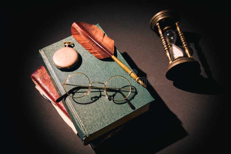 Conceito da literatura A vida do vintage ainda com a ampulheta perto dos vidros em livros velhos aproxima a pena ou a pena e o pu fotos de stock Conceito da literatura A vida do vintage ainda com a ampulheta perto dos vidros em livros velhos aproxima a pena ou a pena e o pu fotos de stock