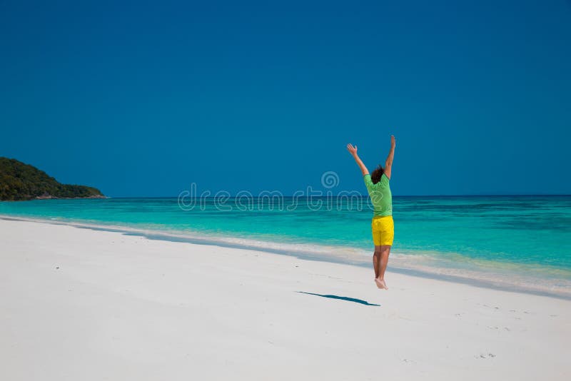 Conceito das férias de verão da praia da liberdade Salto considerável do homem novo fotos de stock Conceito das férias de verão da praia da liberdade Salto considerável do homem novo fotos de stock