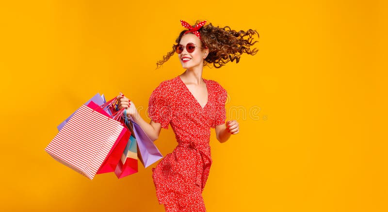 Conceito de compras da compra e vendas da mo?a feliz com pacotes no fundo amarelo foto de stock royalty free Conceito de compras da compra e vendas da mo?a feliz com pacotes no fundo amarelo foto de stock royalty free
