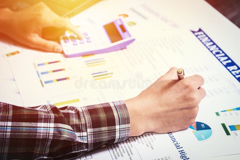 Conceito de contabilidade da finança do negócio: a mão do homem de negócio usando a calculadora e a finança cobrem a análise do r foto de stock royalty free Conceito de contabilidade da finança do negócio: a mão do homem de negócio usando a calculadora e a finança cobrem a análise do r foto de stock royalty free