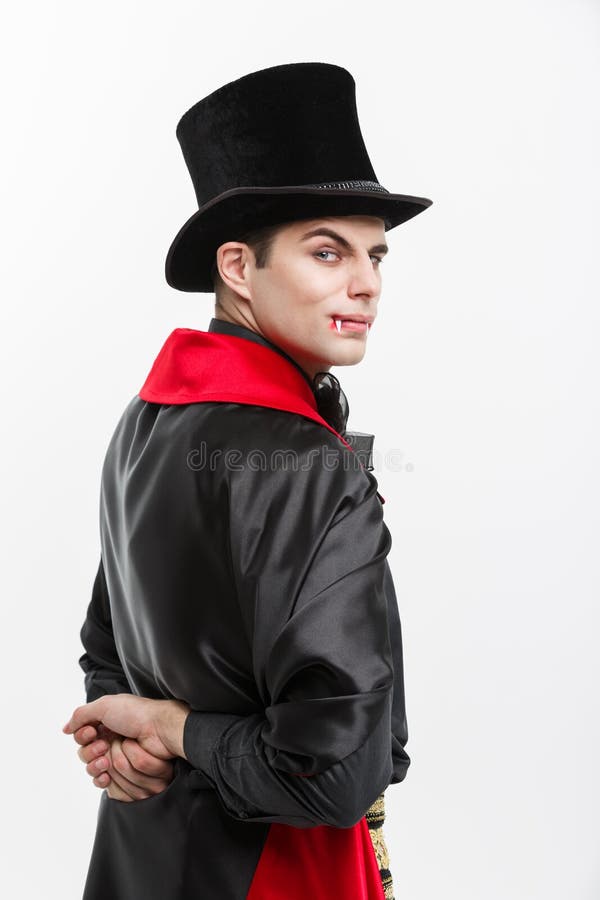 Conceito de Dia das Bruxas do vampiro - retrato do vampiro caucasiano considerável da vista traseira no traje preto e vermelho do