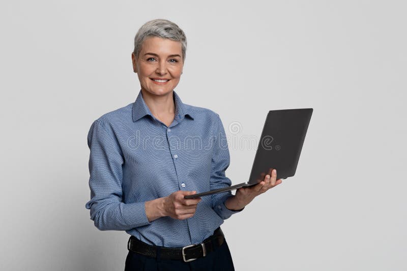 Conceito de emprego na idade adulta. mulher idosa sorridente posando com o laptop nas mãos