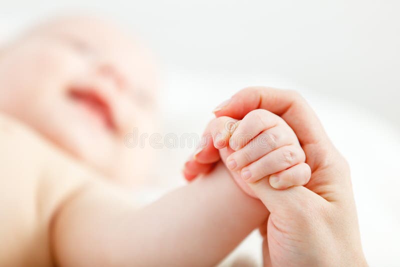 Conceito do amor parental mão do bebê que guarda o dedo da mãe