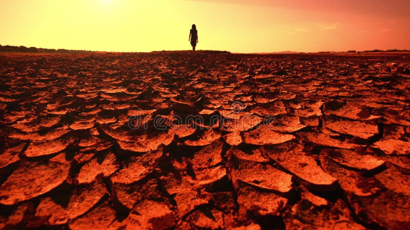 Conceito do aquecimento global Jovem mulher que anda através do deserto